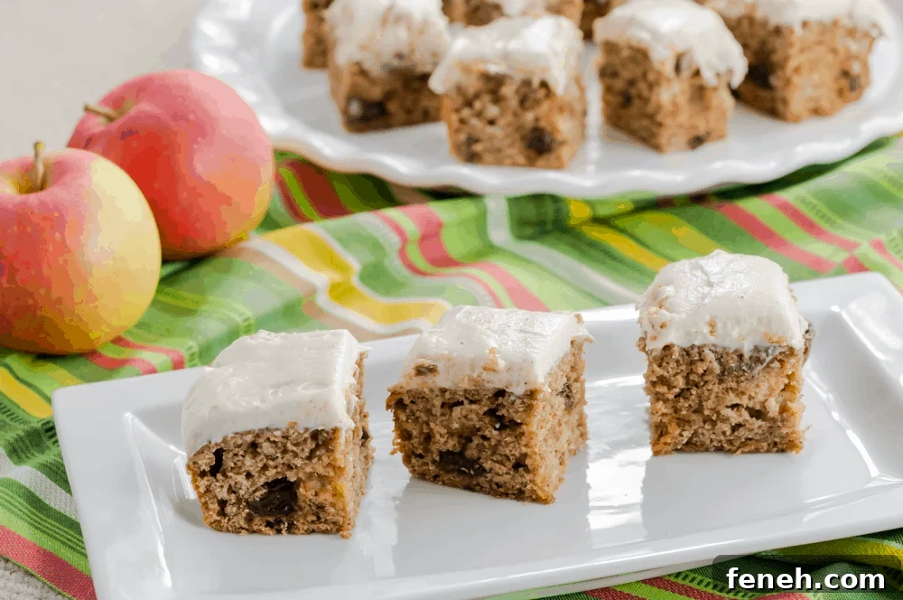 Three raisin spice cake bars frosted with brown sugar cream cheese frosting.