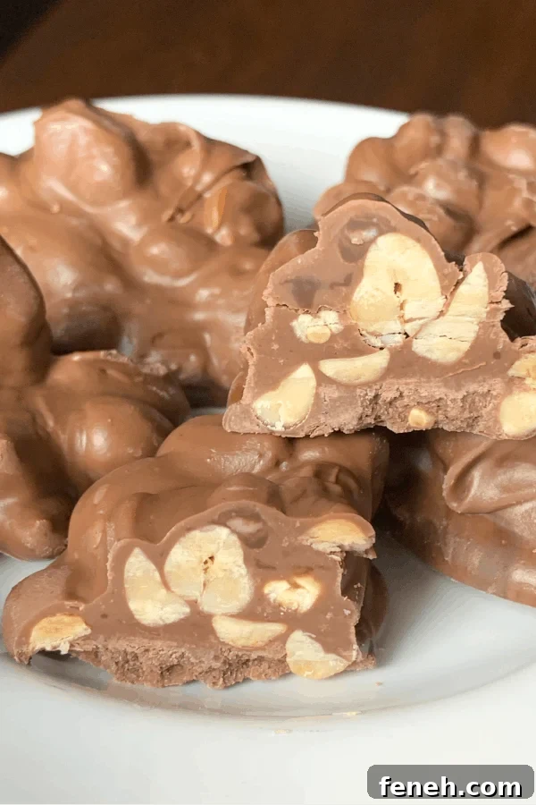 crock pot peanut clusters made with 4 ingredients stacked on a white plate