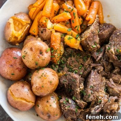 Pressure Cooker Pot Roast in white bowl with potatoes and carrots