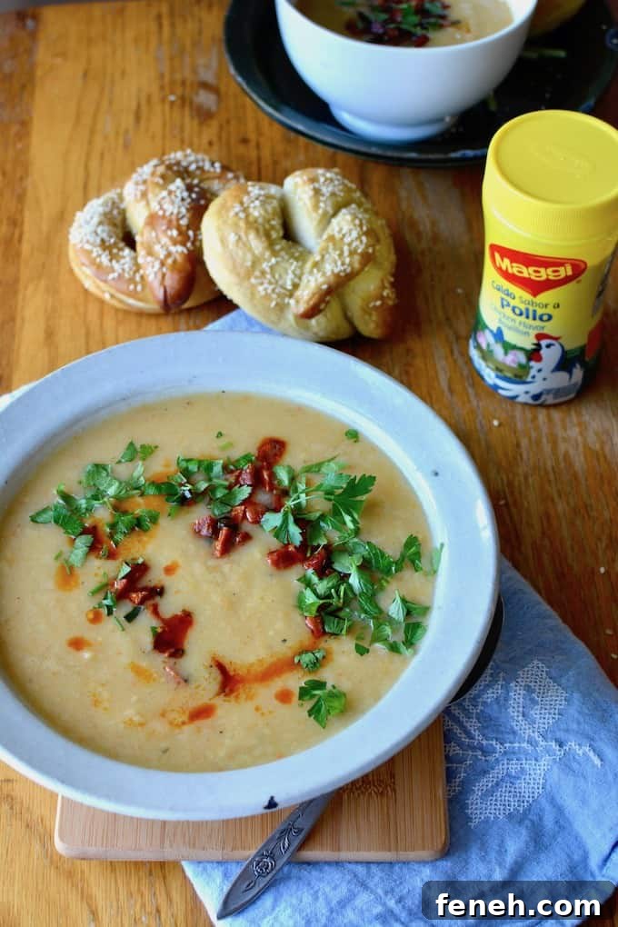 This creamy root vegetable, roasted garlic, and ginger soup actually has no cream whatsoever. It gets topped with a Spanish chorizo-jalapeño relish and is fancy enough for holiday celebrations yet easy enough for weeknight dinners. #ad #rootvegetablesoup #healthysoup #easysoup #fallsoup #dairyfreesoup #rootvegetables #chorizo