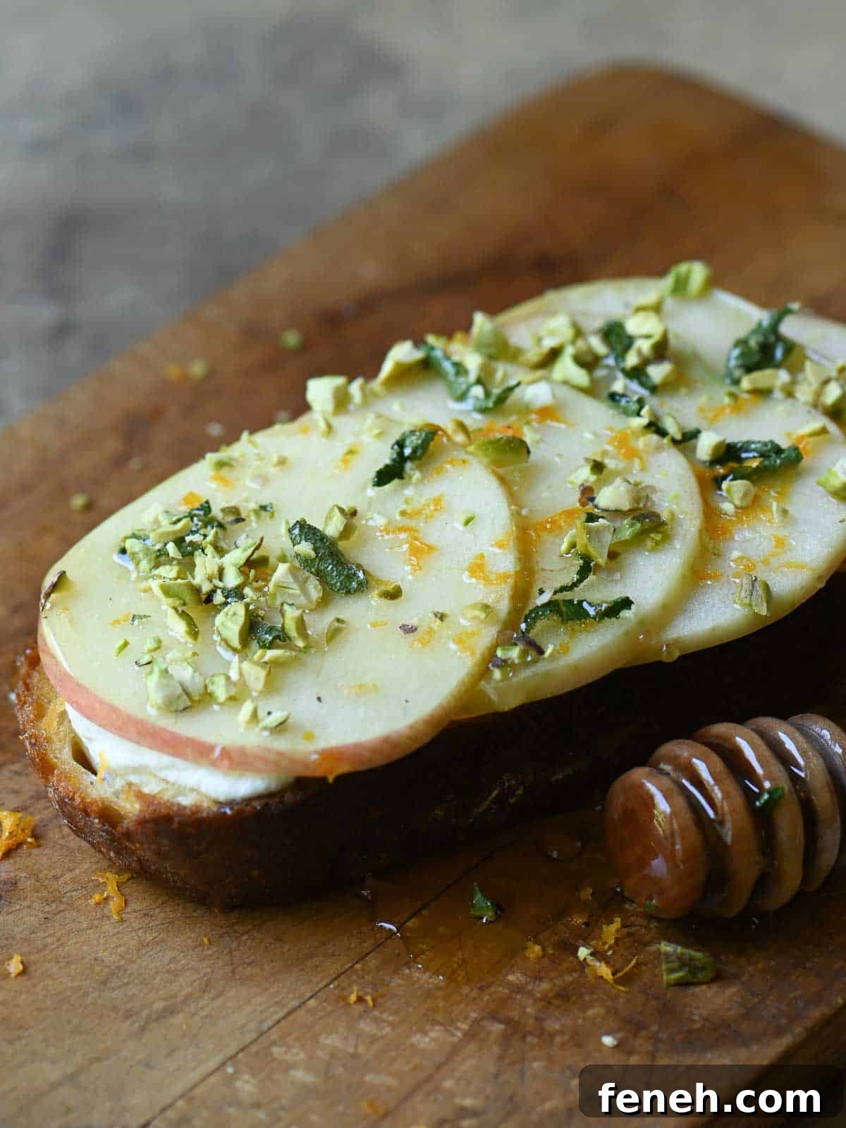 Apple toast with ricotta, honey and nuts on a cutting board.