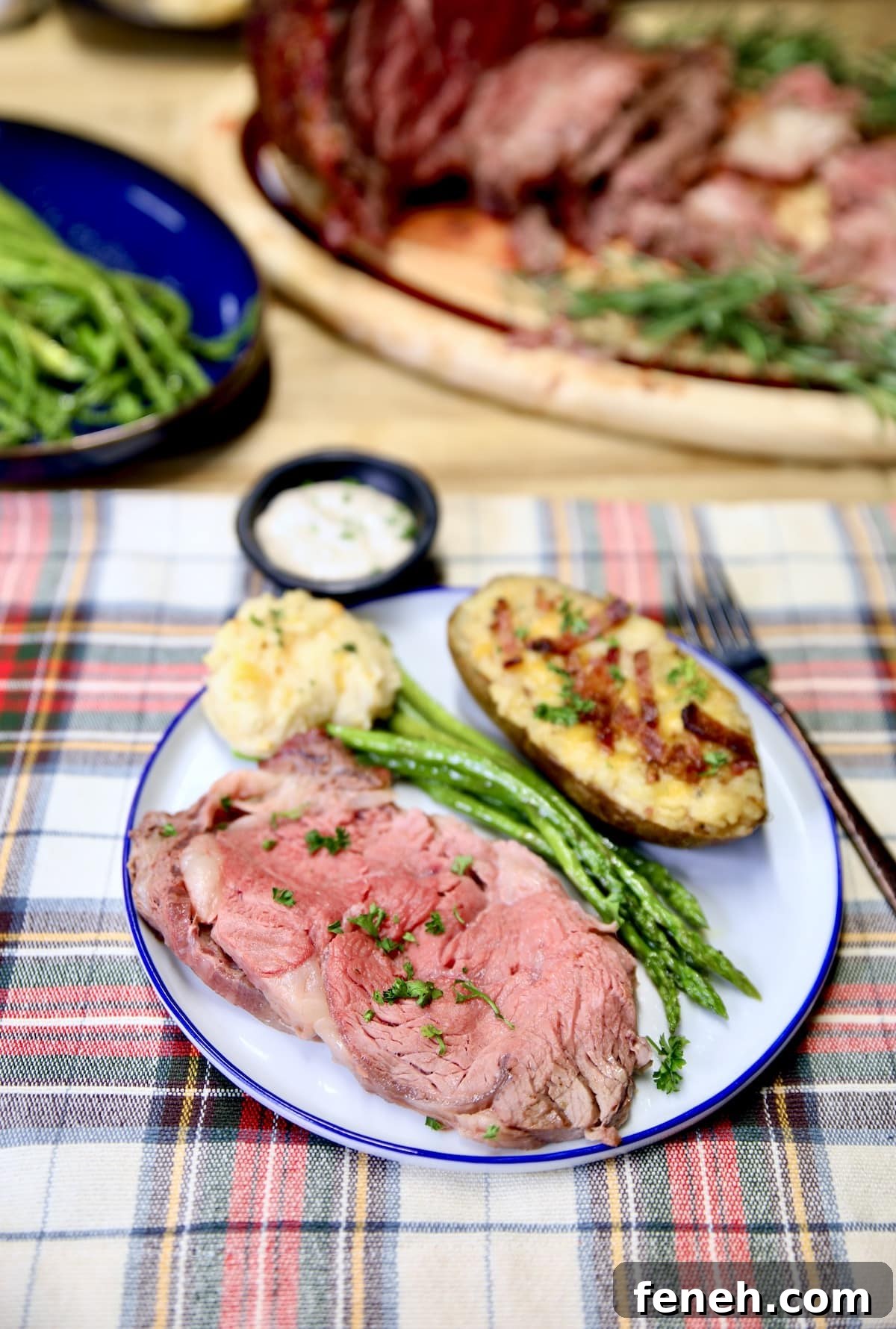Plate of rare prime rib, potato, asparagus.