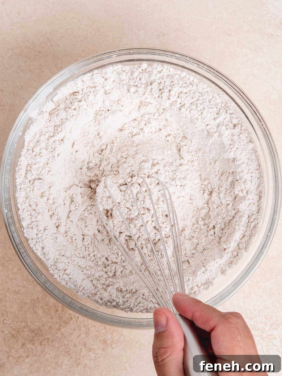 Whisking flour, baking soda, salt, and chai spice in a bowl.