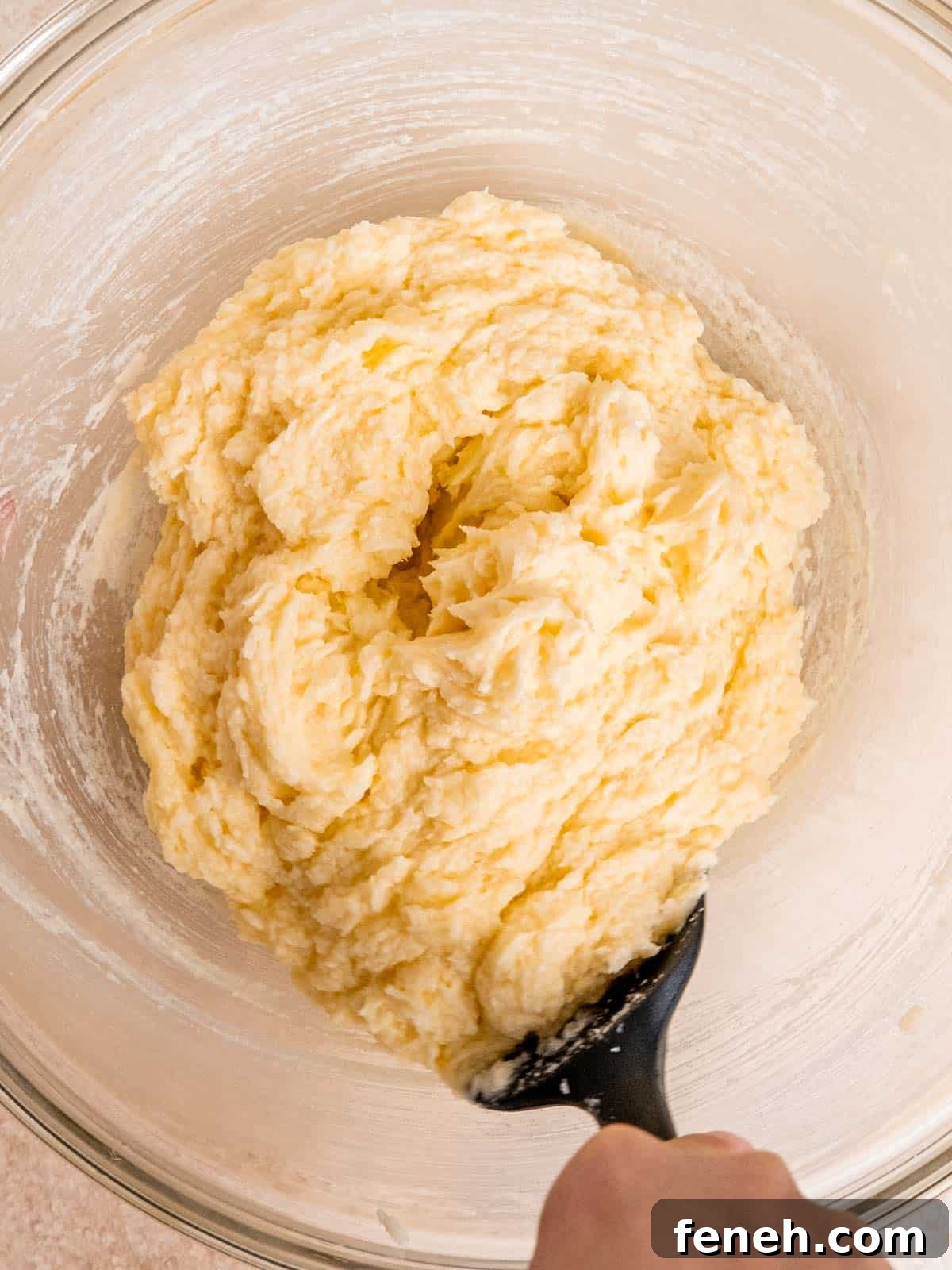 Butter, sugar, eggs, vanilla extract and lemon extract mixed together in a bowl.
