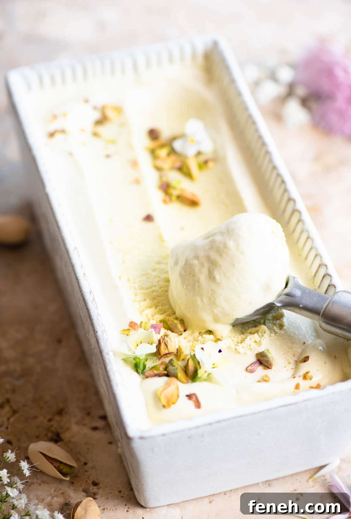 Pistachio ice cream in a loaf dish with a scoop of ice cream at one end