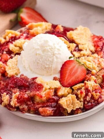 Strawberry dump cake topped with a scoop of vanilla ice cream.