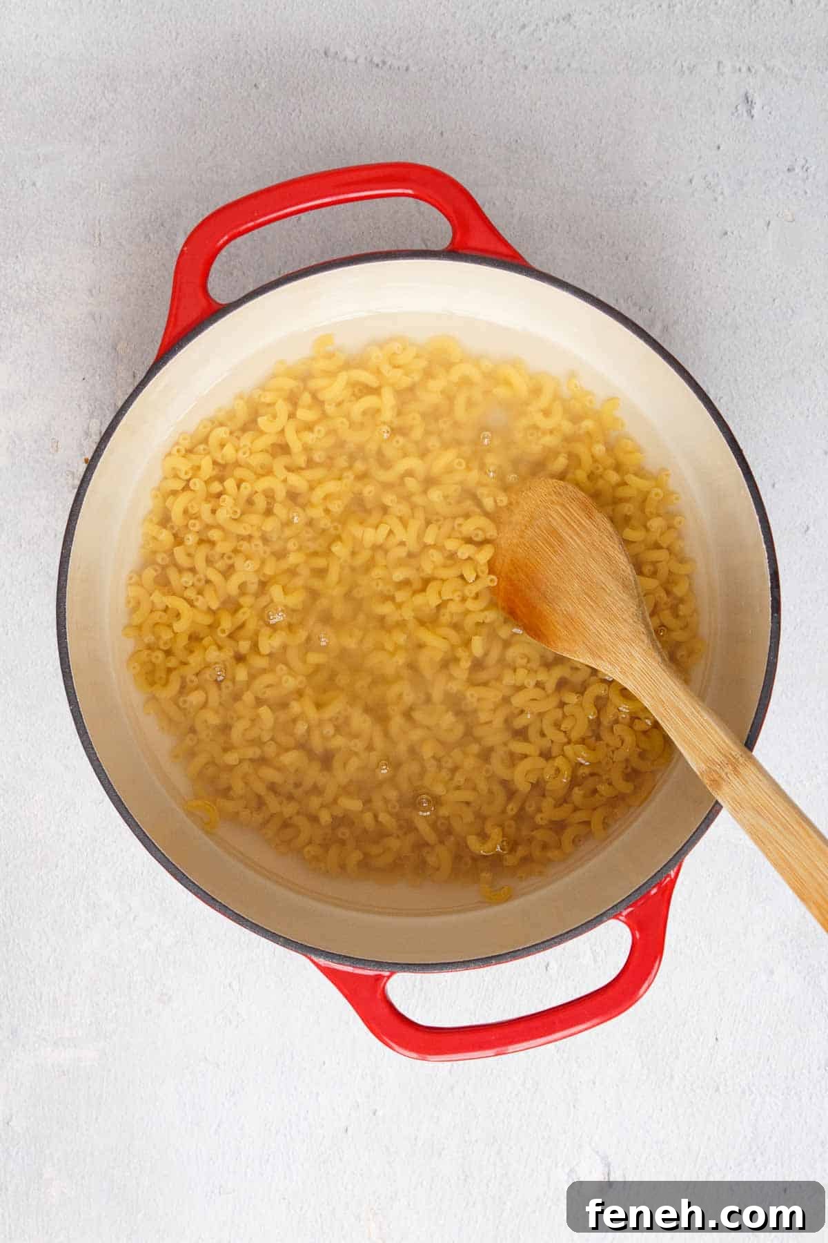 Uncooked macaroni in a pot covered with water