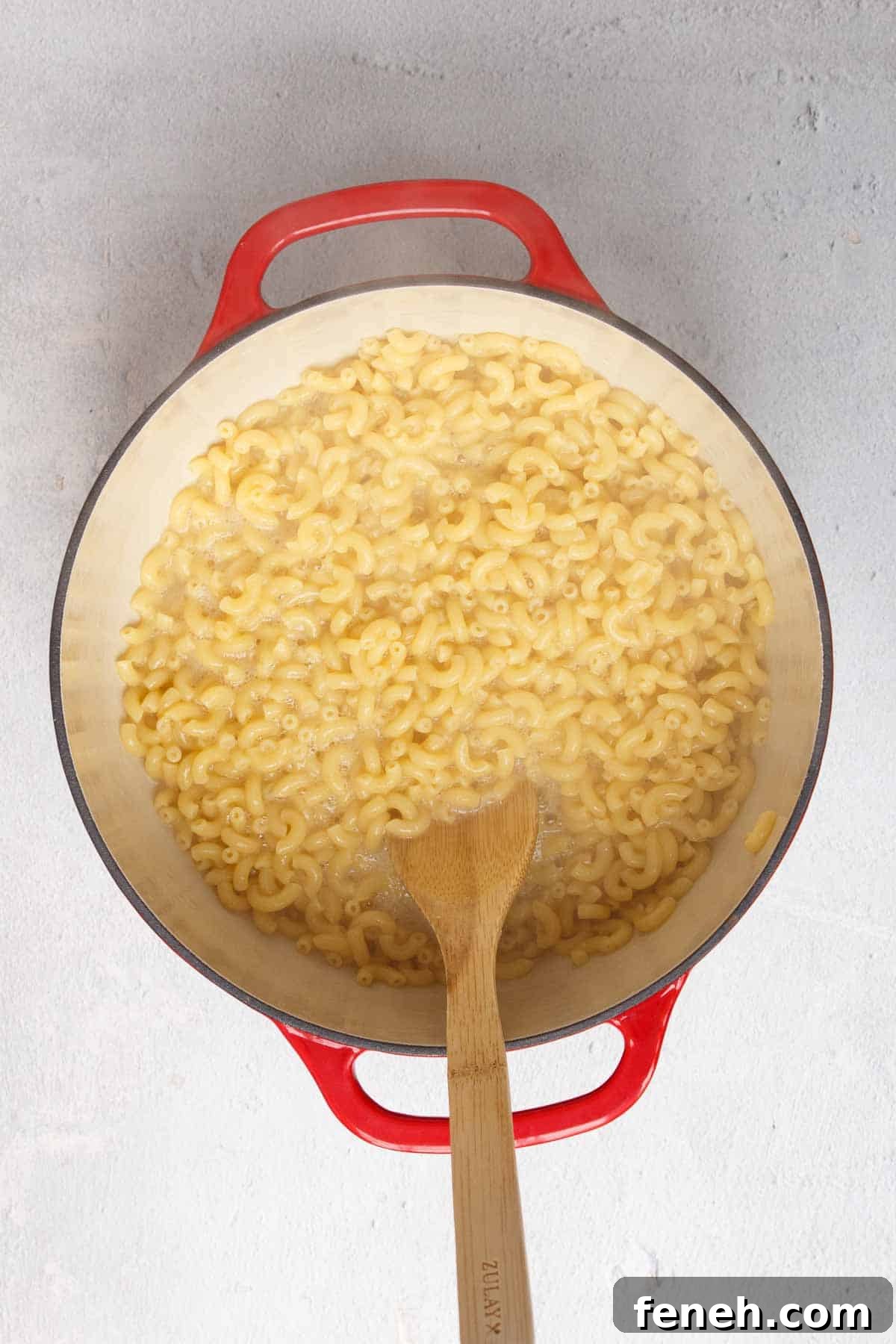 Macaroni nearly al dente with a small amount of water remaining