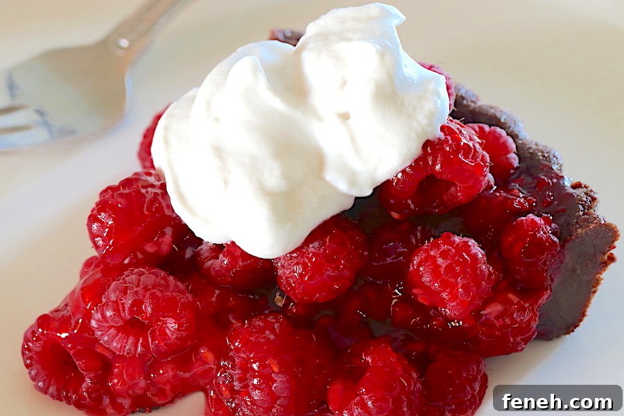 A slice of Fresh Raspberry Tart with whipped cream