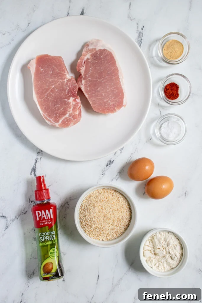 Ingredients for air fryer schnitzel laid out on a tabletop including pork chops, breadcrumbs, flour, and eggs.