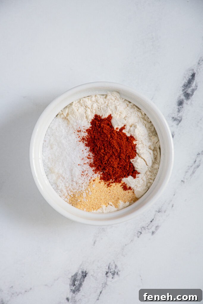 Small white bowl with flour, salt, garlic powder, and paprika.