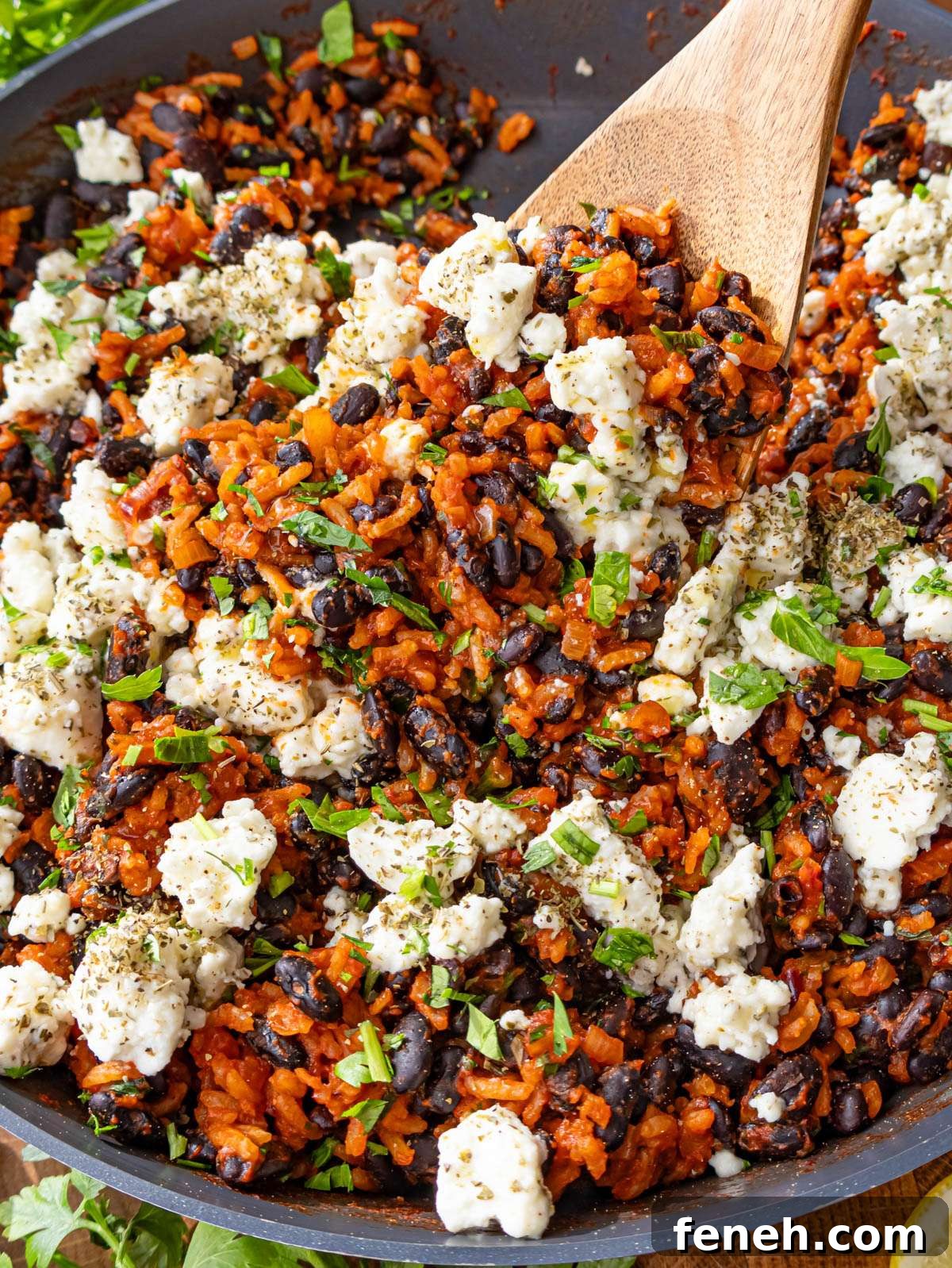 Close up of Mediterranean black beans and rice with marinated feta and fresh parsley.
