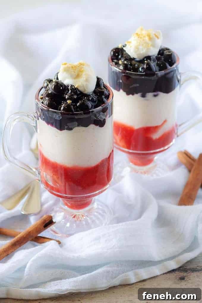 The final picture showing the finished blueberry cheesecake parfaits in clear glass mugs garnished with fresh whipped cream and crumbled graham crackers.