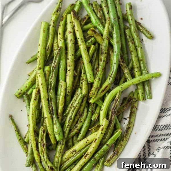 Grilled green beans on a white plate.