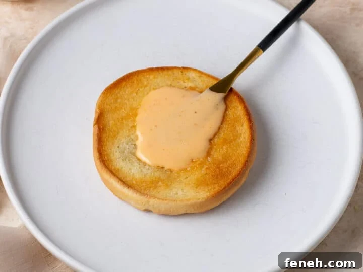 toasted bun with creamy bang bang sauce spread on top