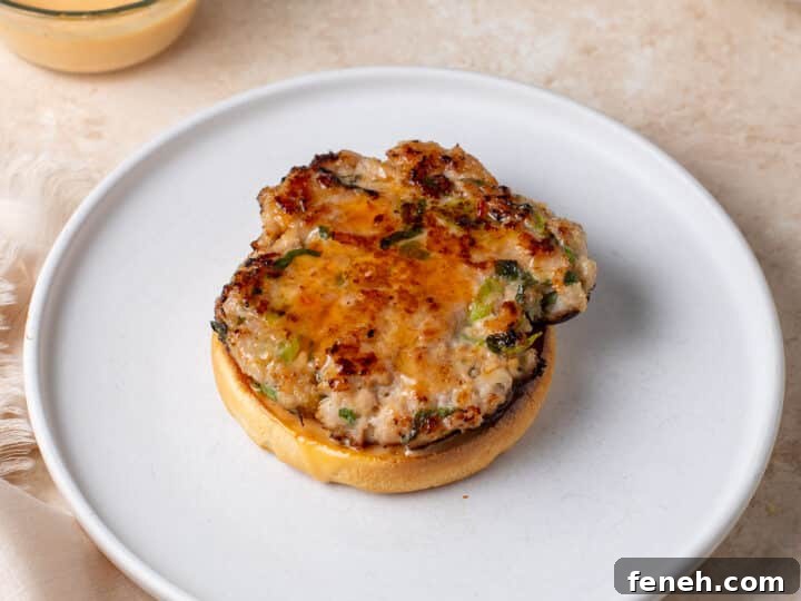 cooked chicken patty on a bun brushed with sweet chili sauce