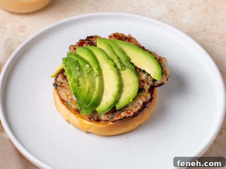 sliced avocado layered on top of a chicken patty