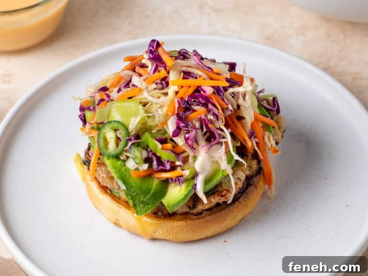 chicken burger topped with avocado and fresh sesame slaw