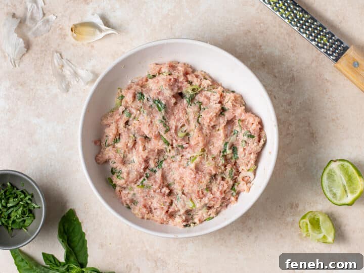 ground chicken mixture fully combined with herbs and seasonings in a bowl