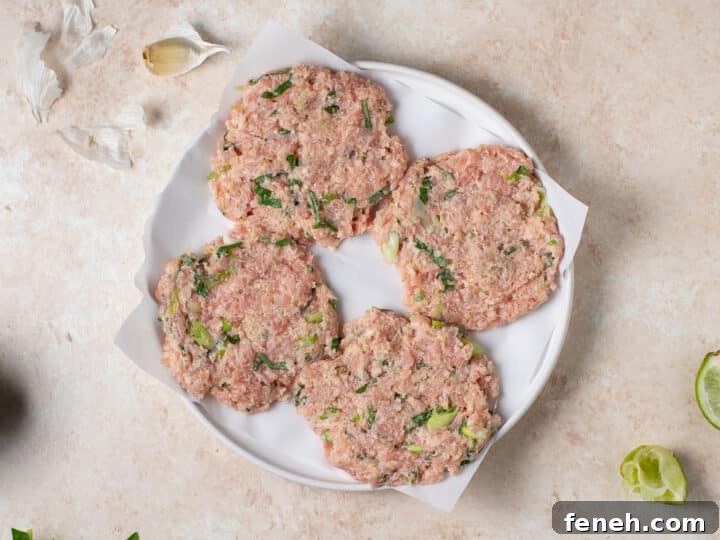 uncooked chicken patties shaped and placed on parchment paper
