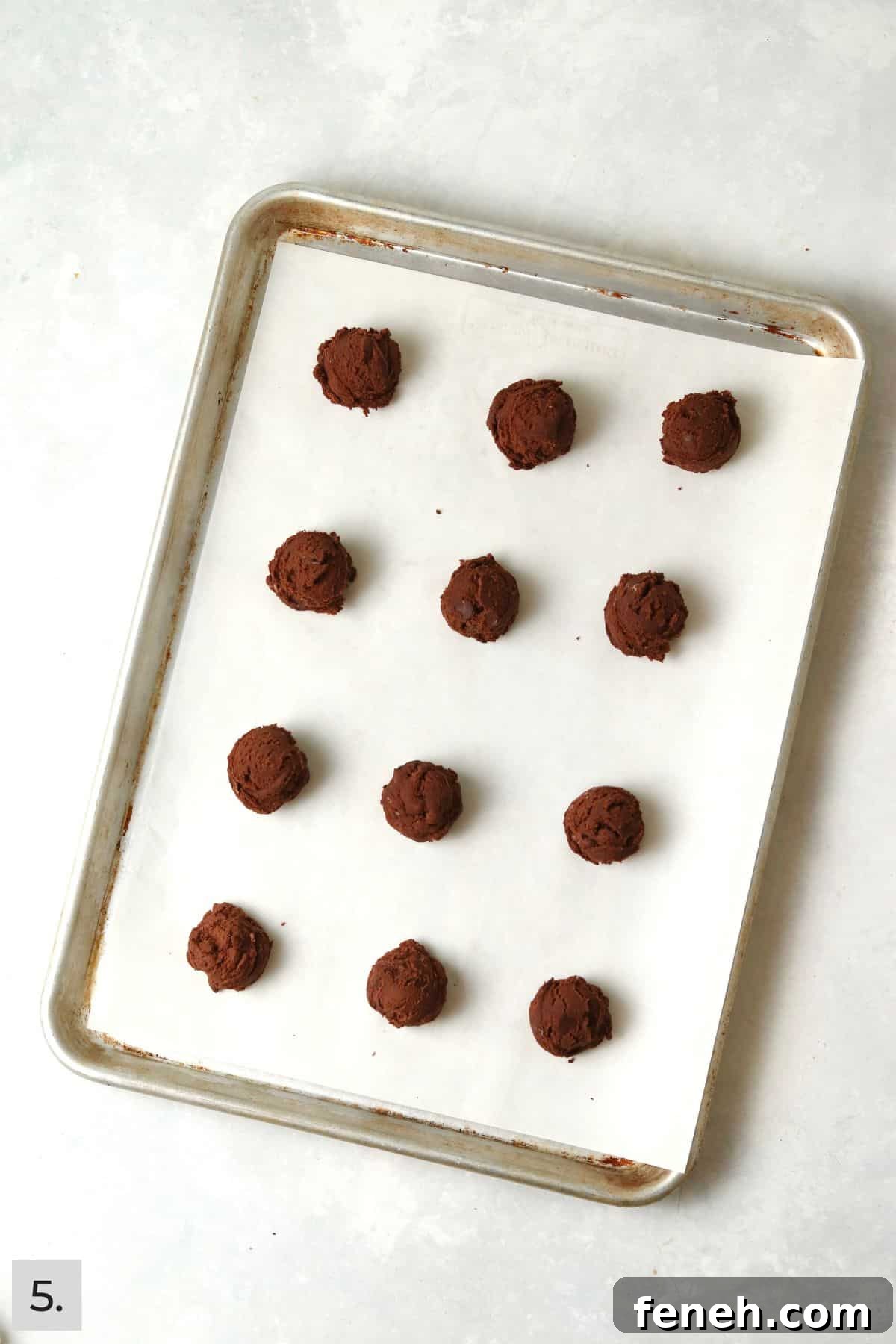 Unbaked brownie cookie dough balls on a baking sheet.