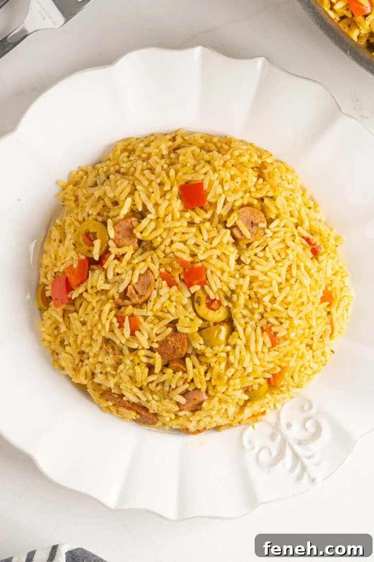 a plate of yellow rice with sausages