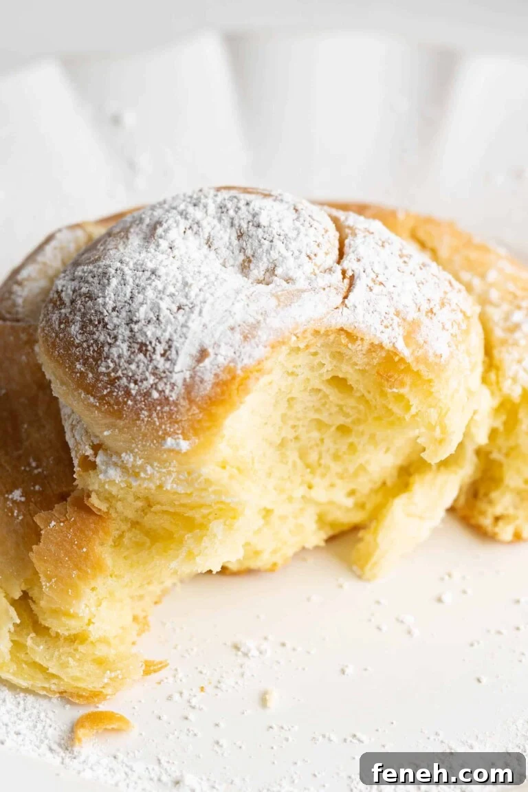 A sweet bun on a plate with a bite taken
