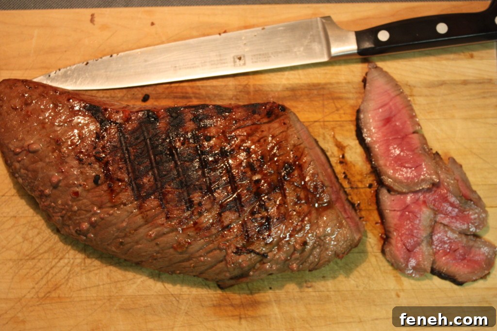 Sliced London Broil on a wooden cutting board.