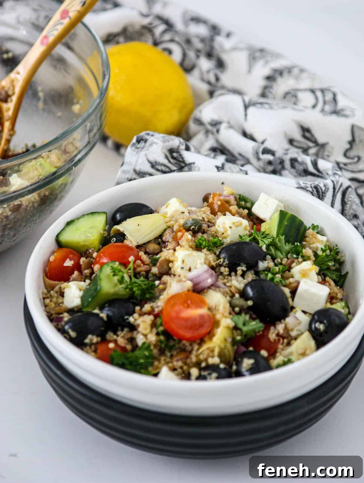 Quinoa and lentil salad in a black and white bowl.