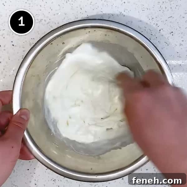 Whisking together yoghurt and garlic in a small bowl