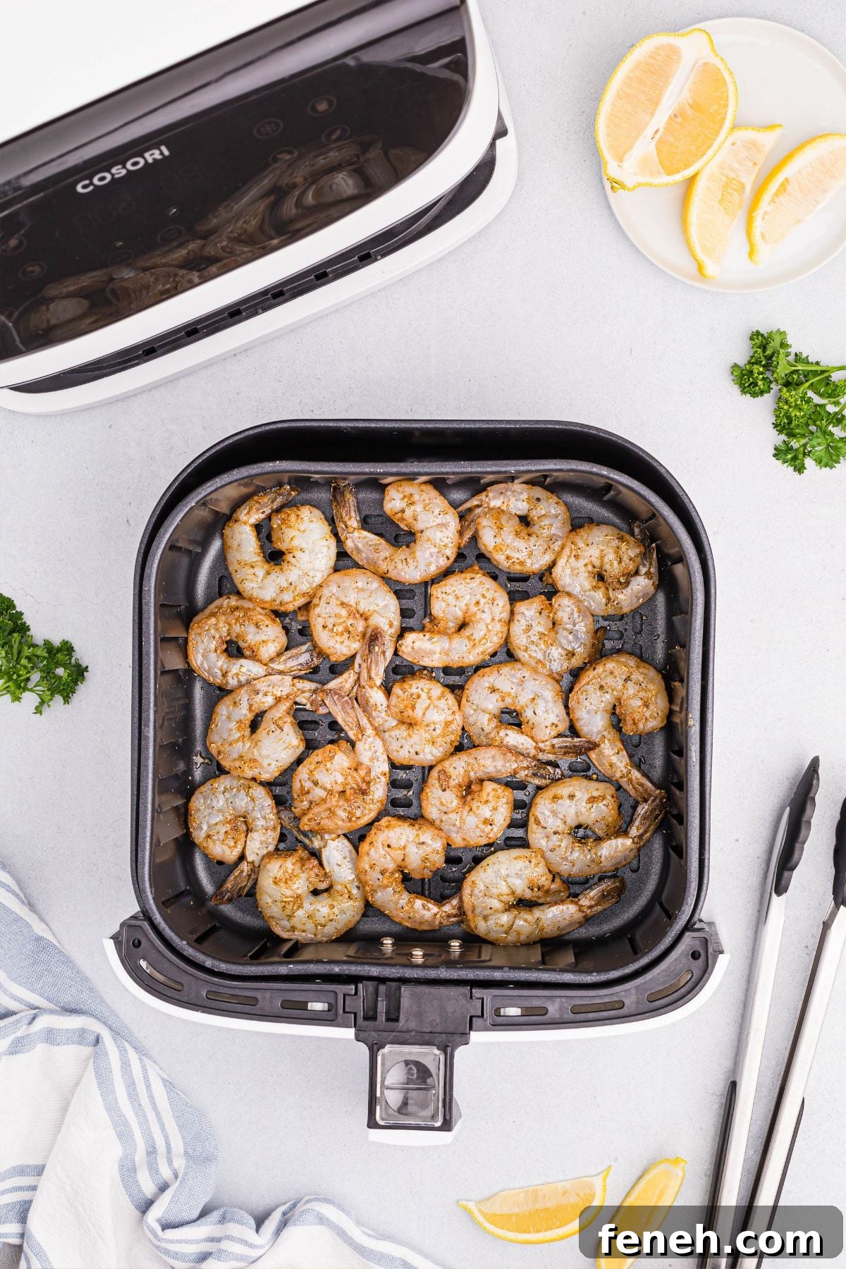 Seasoned uncooked shrimp in air fryer basket