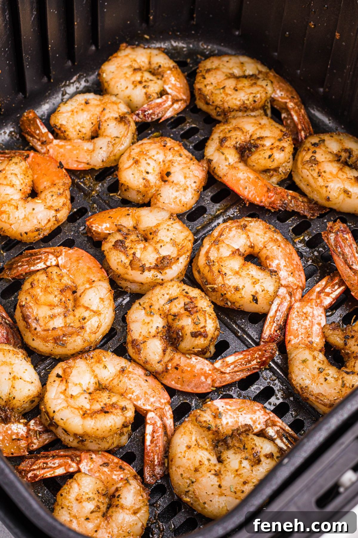 Juicy seasoned shrimp in air fryer basket