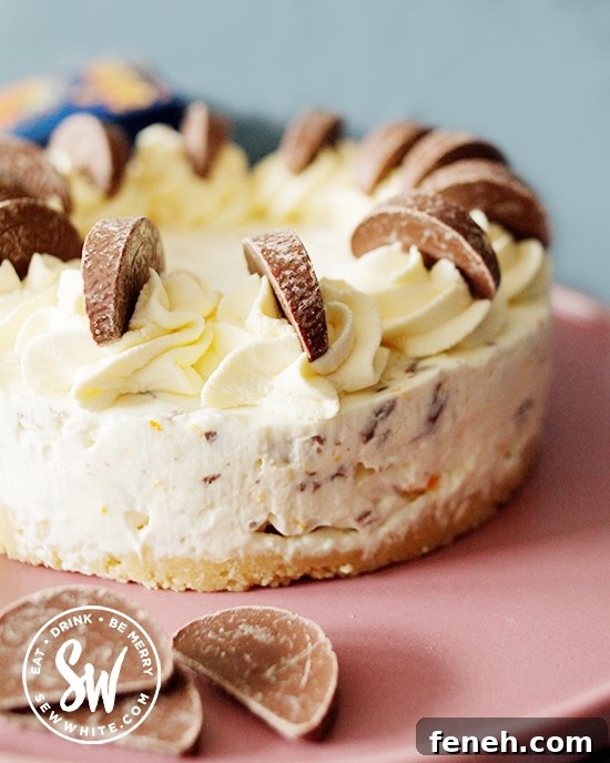 The finished chocolate orange cheesecake topped with cream swirls with Terry's chocolate orange pieces.
