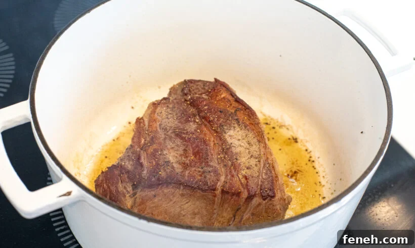 searing chuck roast in white cast iron pot