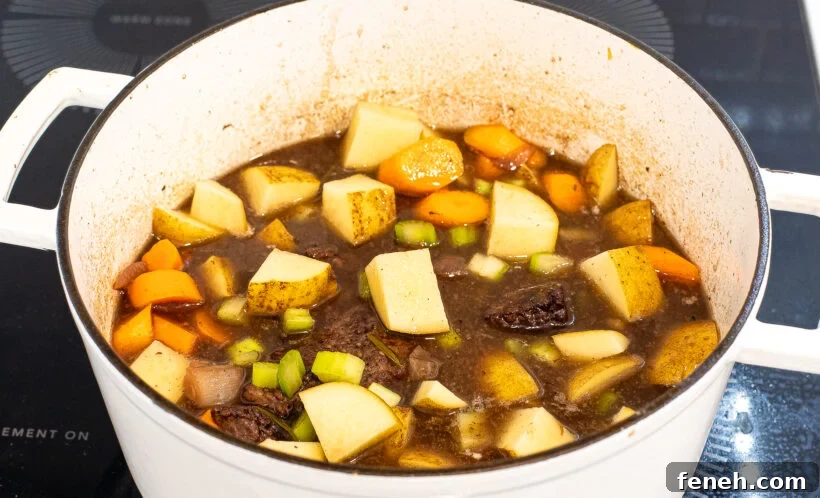 adding potatoes, carrots and celery to large pot