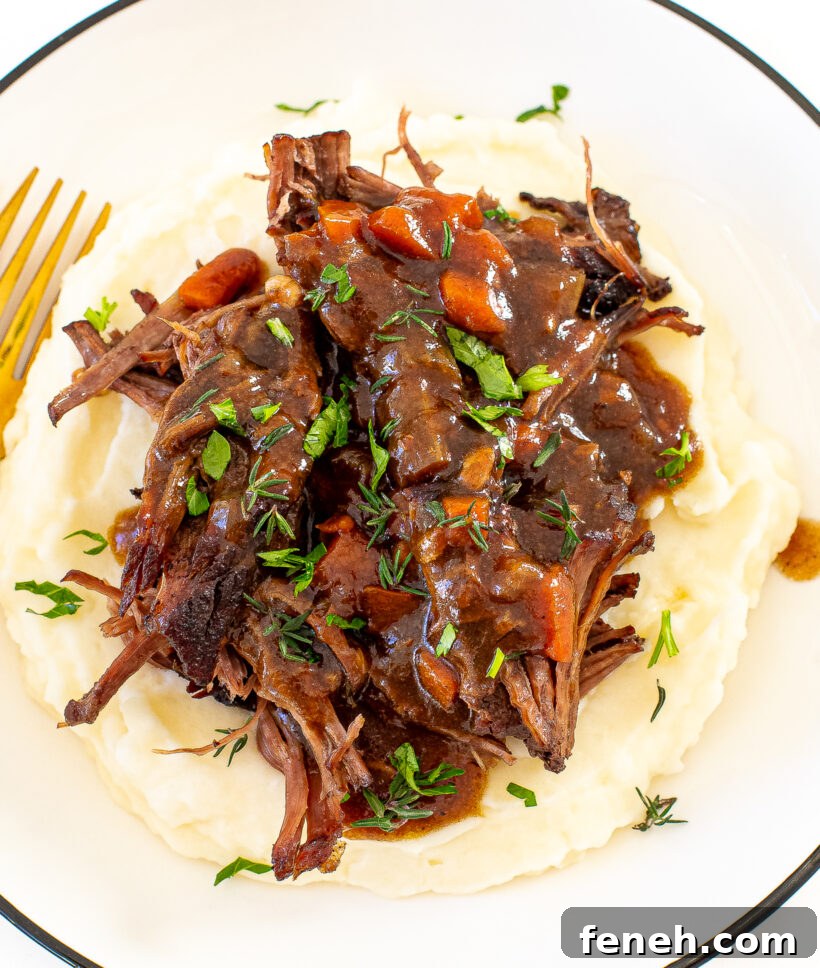 shredded cider braised pot roast on a bed of creamy mashed potatoes