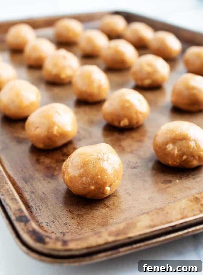 3 ingredient peanut butter balls lined up on a baking tray