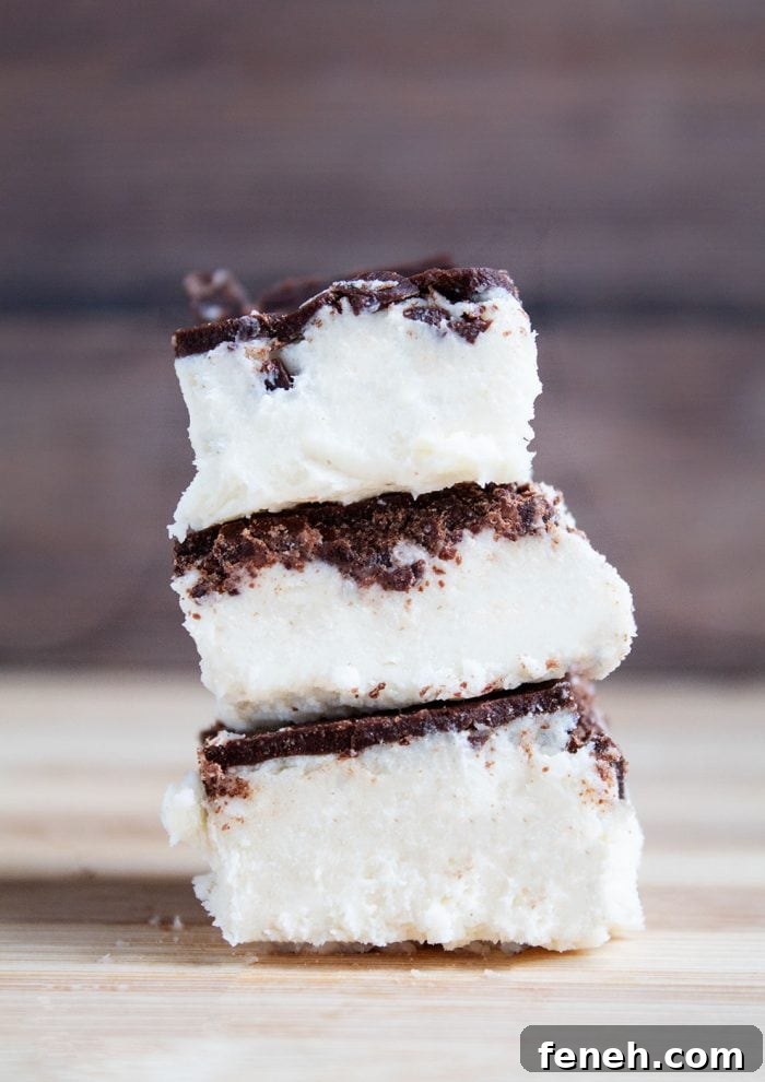 three keto salted caramel fat bomb bars stacked on top of each other in front of dark wood