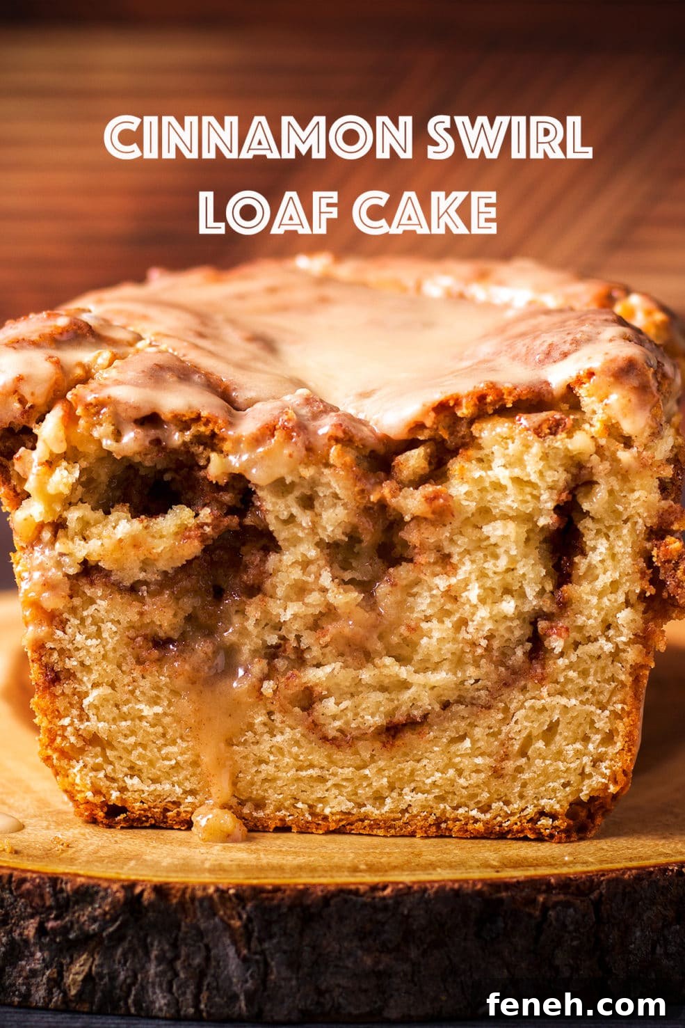 Cinnamon Swirl Loaf Cake on a wood cutting board that's been cut in half so you can see the cinnamon swirl inside the cake.