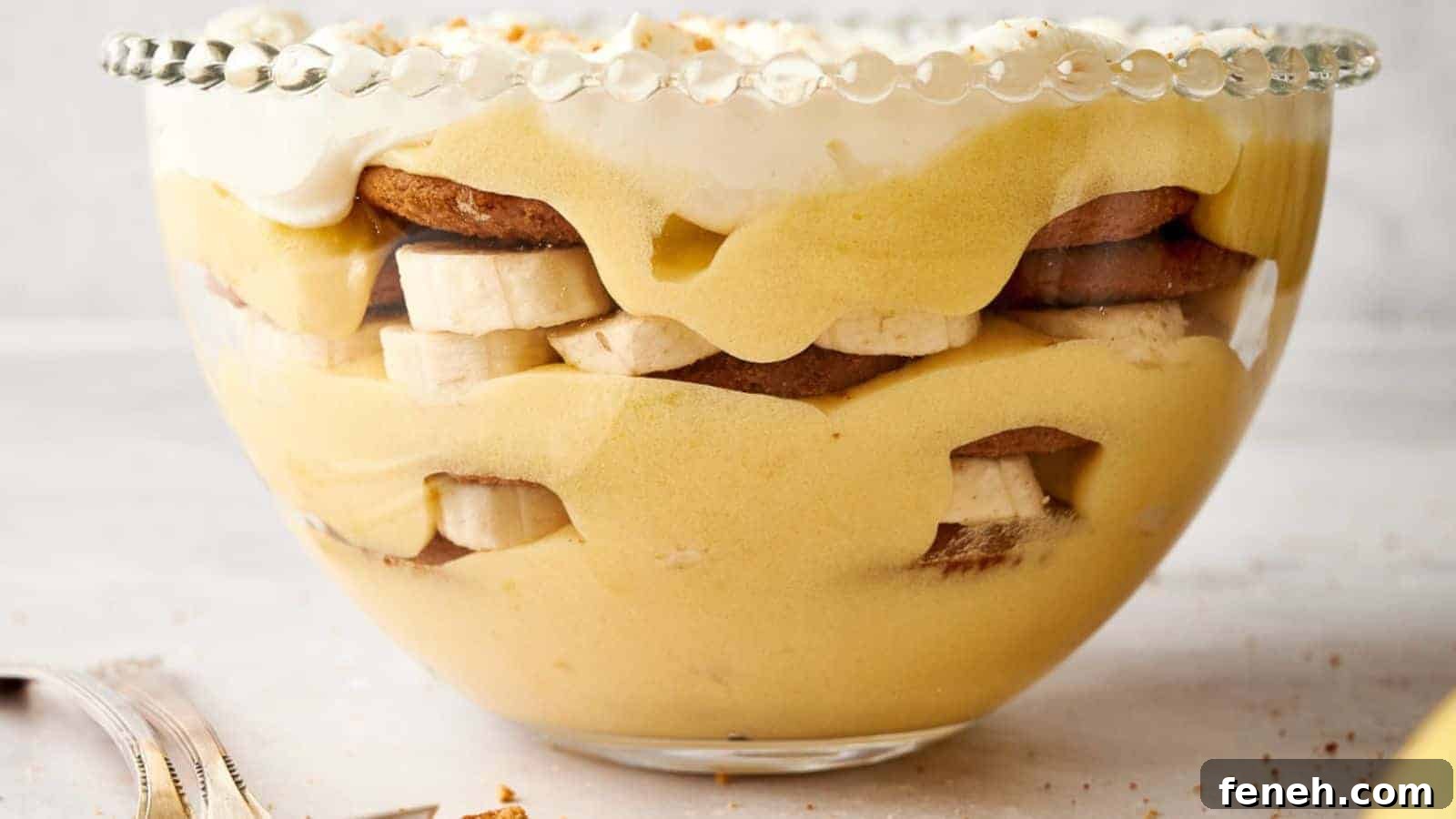 Banana pudding in a bowl with whipped cream and bananas.