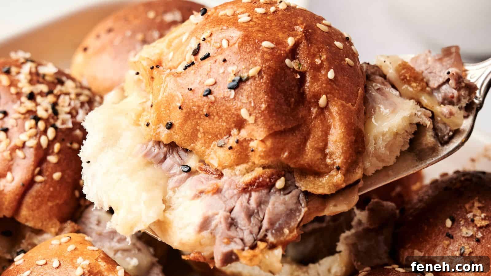Close-up of a fork lifting a beef sandwich topped with sesame seeds on a soft bun, with more sandwiches in the background.
