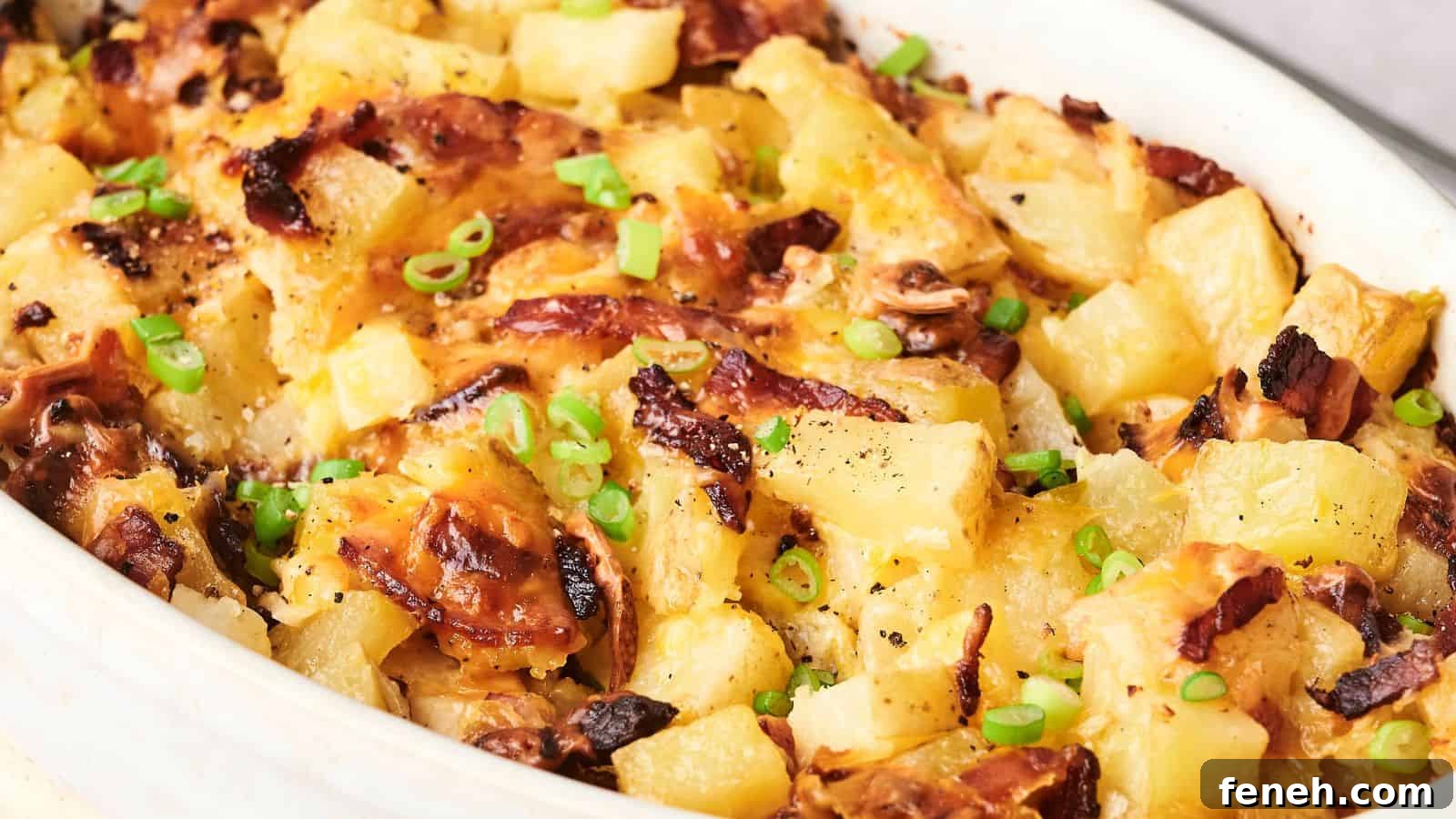 A baked dish with melted cheese, diced pineapples, browned bacon, and chopped green onions on top.
