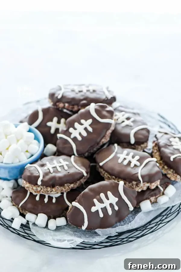 Football Rice Krispie Treats on a black wire platter garnished with mini marshmallows