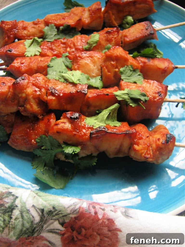 Sweet and Spicy Chicken Kebabs on a blue plate with a floral napkin
