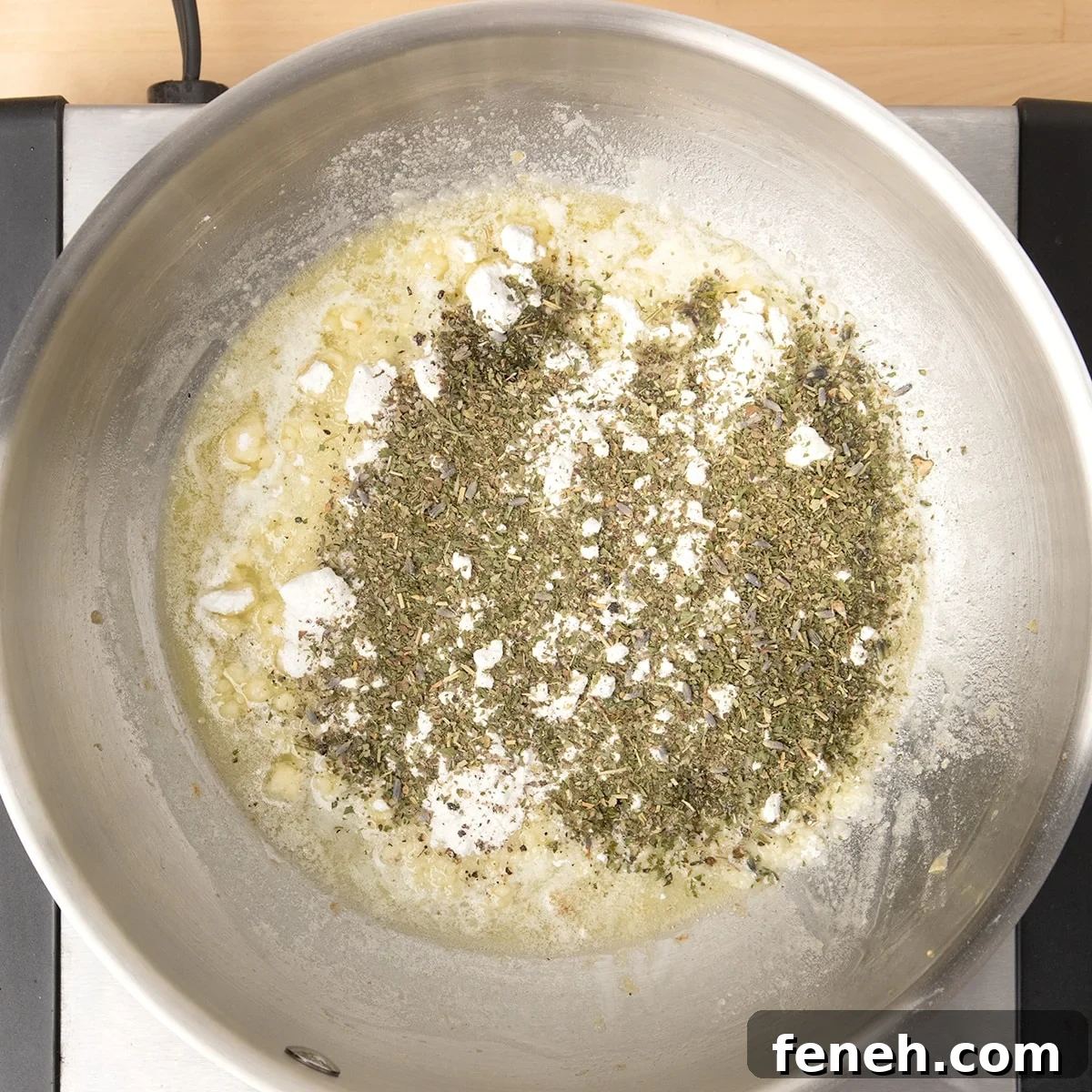 round metal saucepan with layered melted butter, white gluten free flour, dried herbs de provence, salt and papper