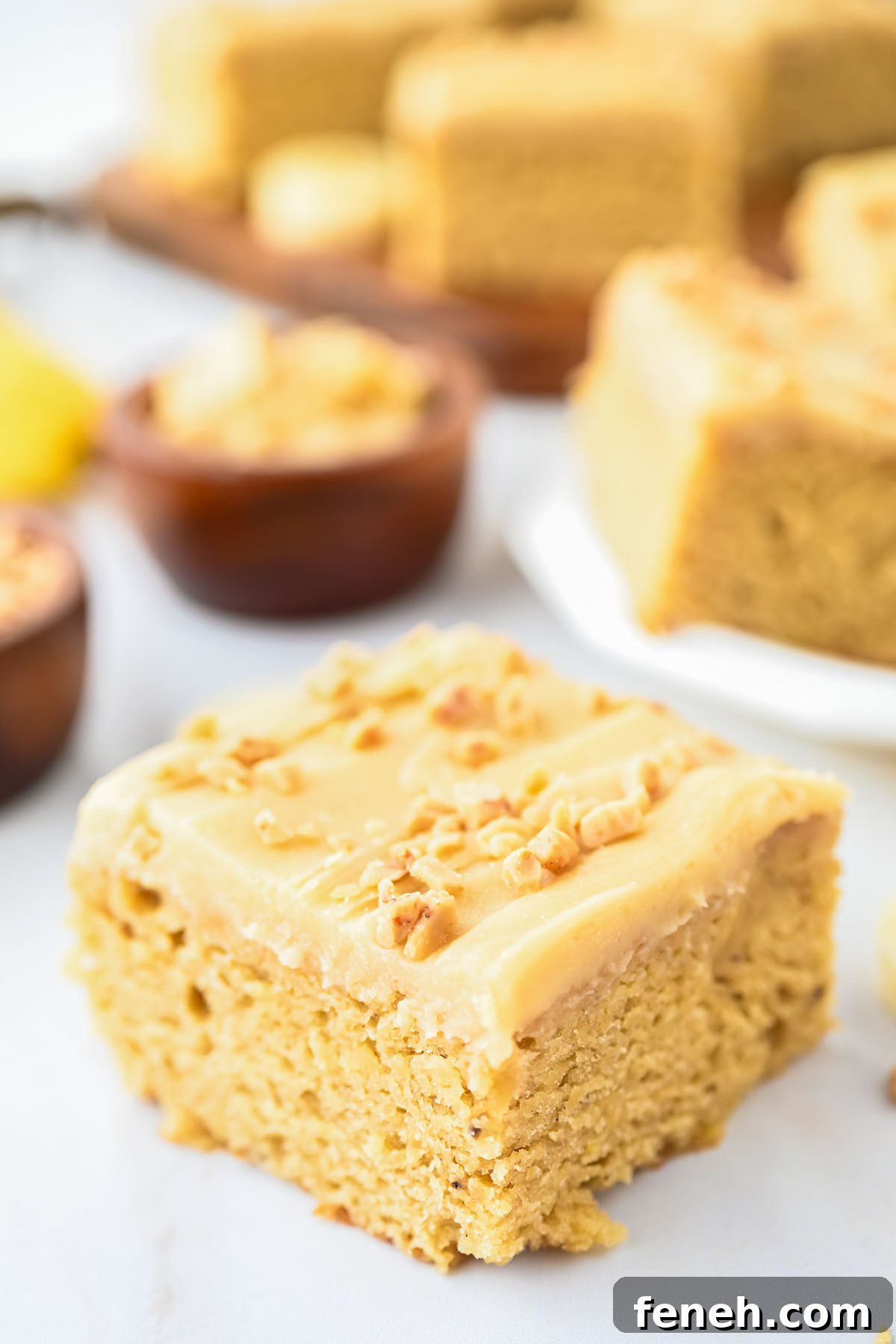 Banana Blondie topped with frosting and chopped nuts.