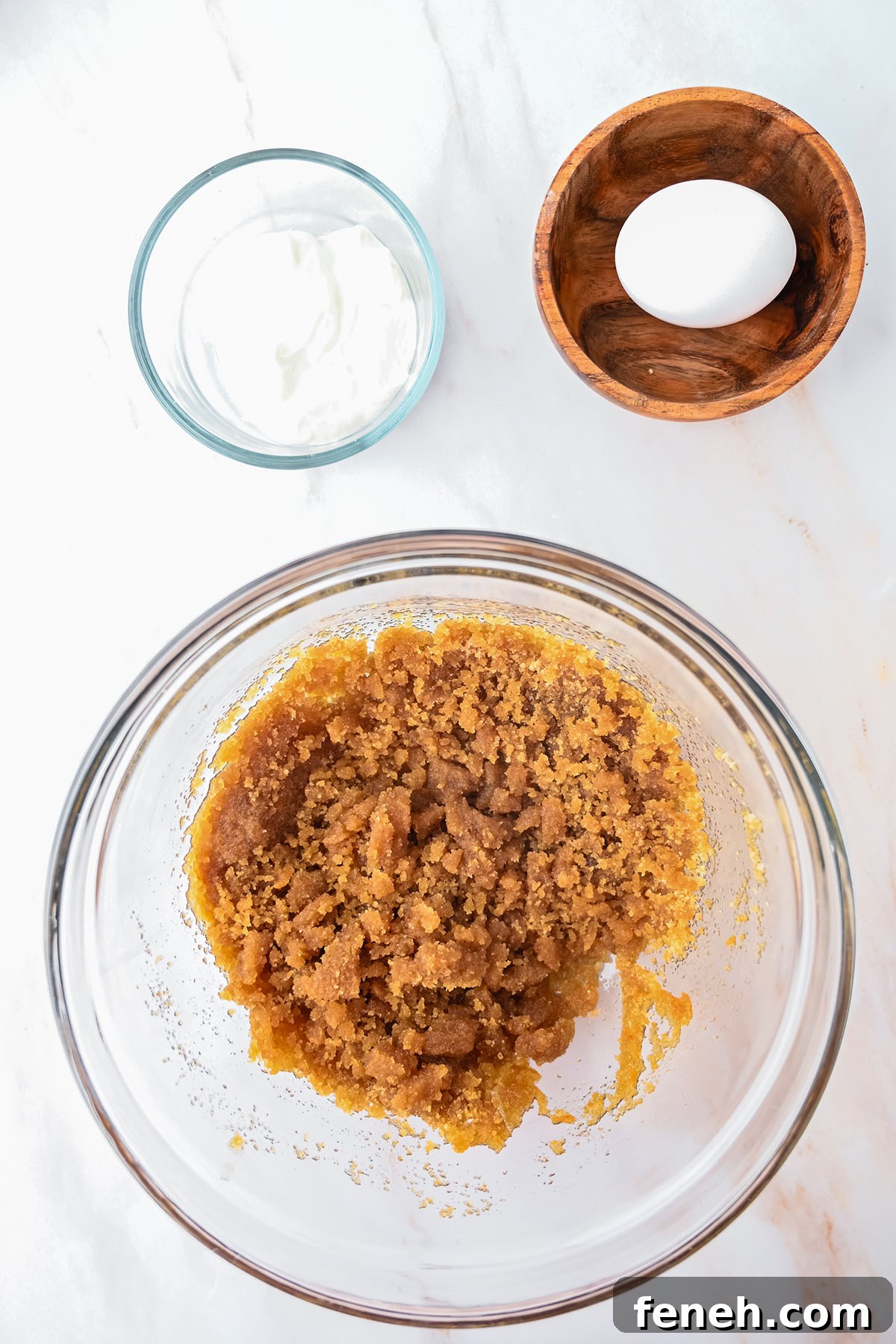 Brown sugar and browned butter in a glass mixing bowl.