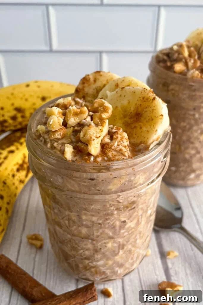 Banana Bread Overnight Oats Recipe topped with sliced Bananas, chopped pecans, and bananas in the background