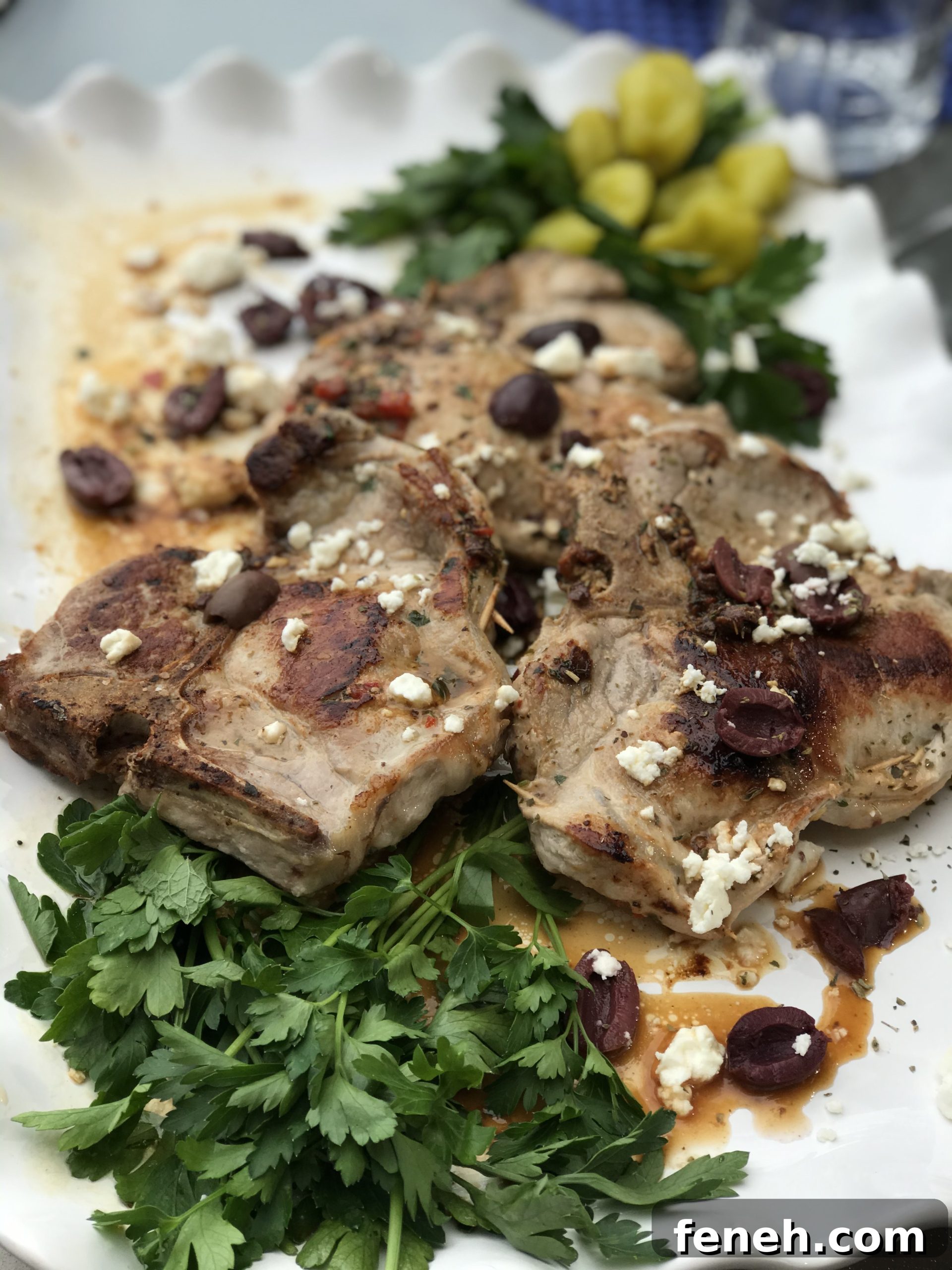 Mediterranean stuffed pork chops on a white platter.