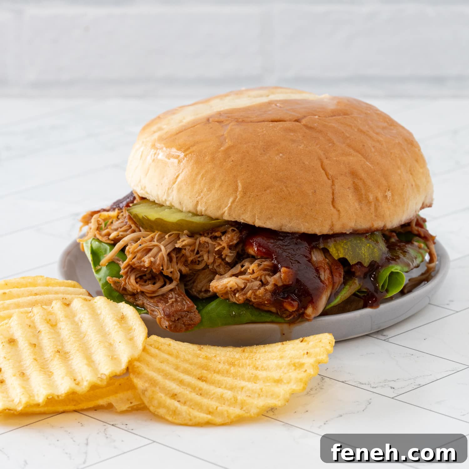 Instant Pot pulled chicken sandwich with pickles and bbq sauce.